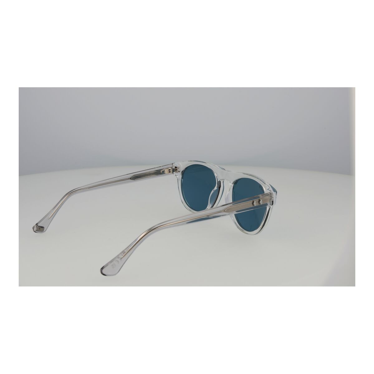 Detail van de Web Eyewear zonnebril met blauwe glazen en transparante montuur.