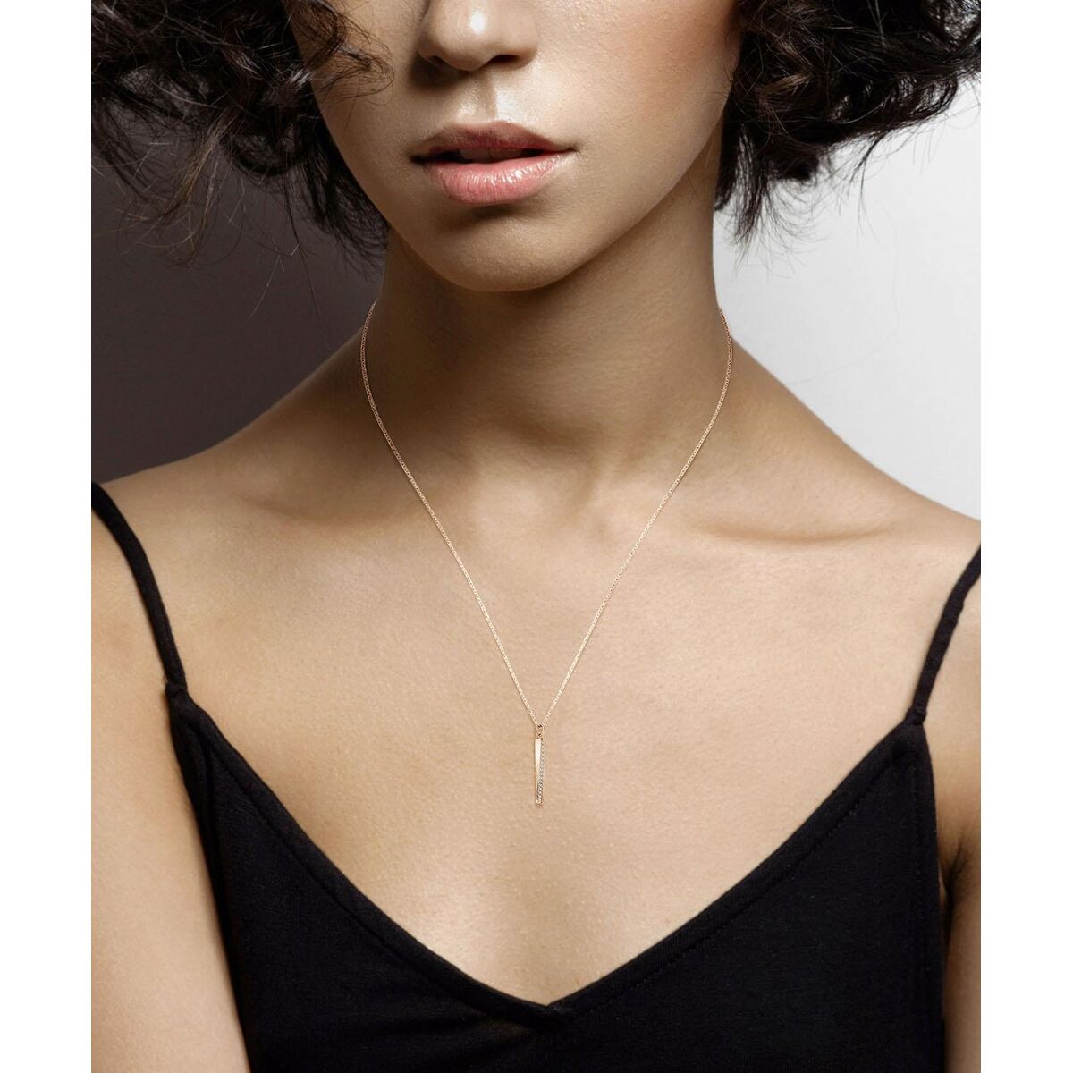 Detailweergave van de gouden Hugo Boss ketting met een elegante hanger, gedragen door een model.
