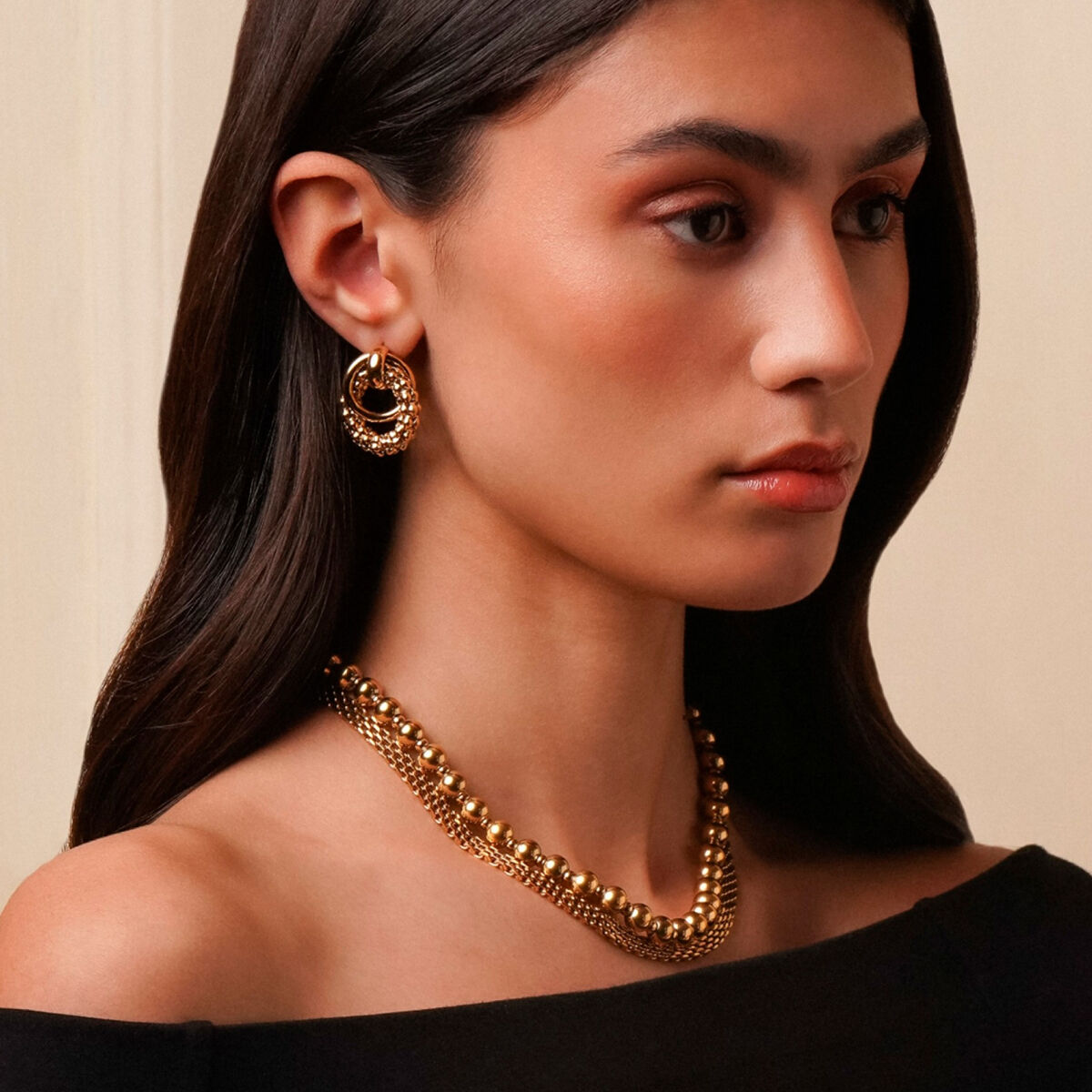 Elegante gouden One Jewels oorbellen, gedragen door een model met een stijlvolle uitstraling.