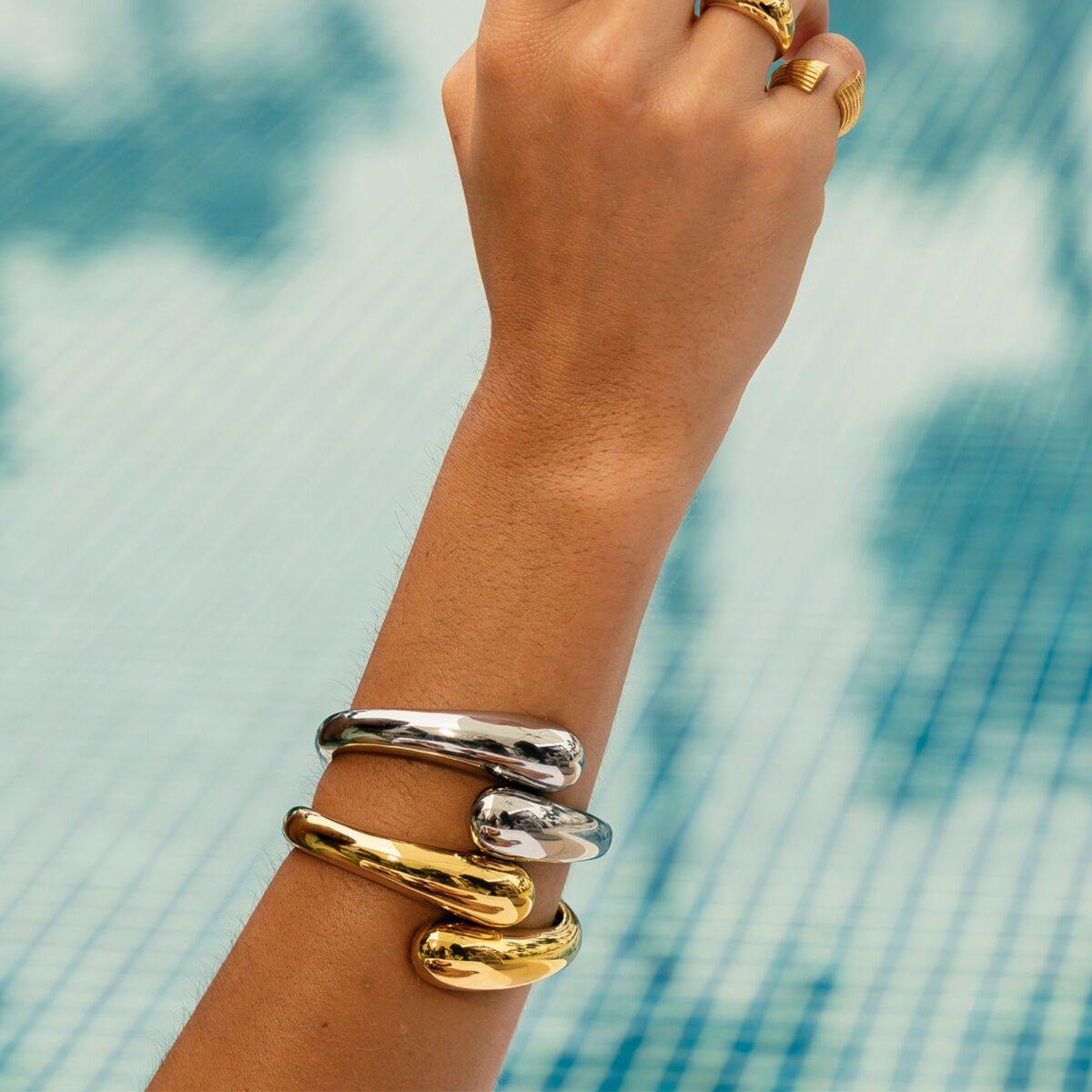 Zilverkleurige One Jewels armband gedragen om een hand, met een glanzend en elegant ontwerp.