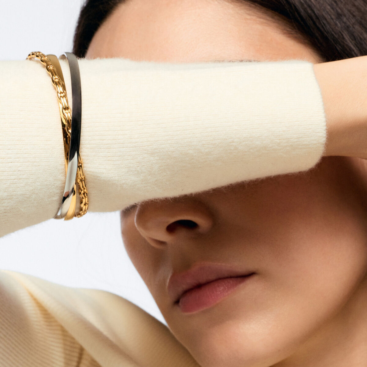 Detail van de gouden One Jewels armband om een pols, elegant en verfijnd ontwerp.