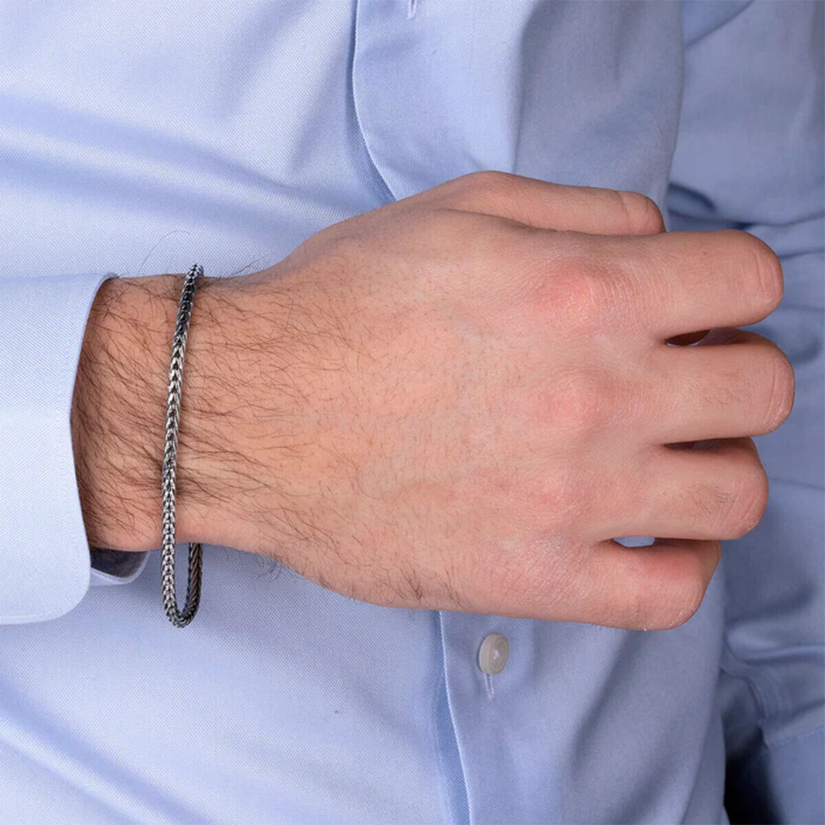 Zilverkleurige Albert M. ketting van 19 cm, gedragen om een hand.