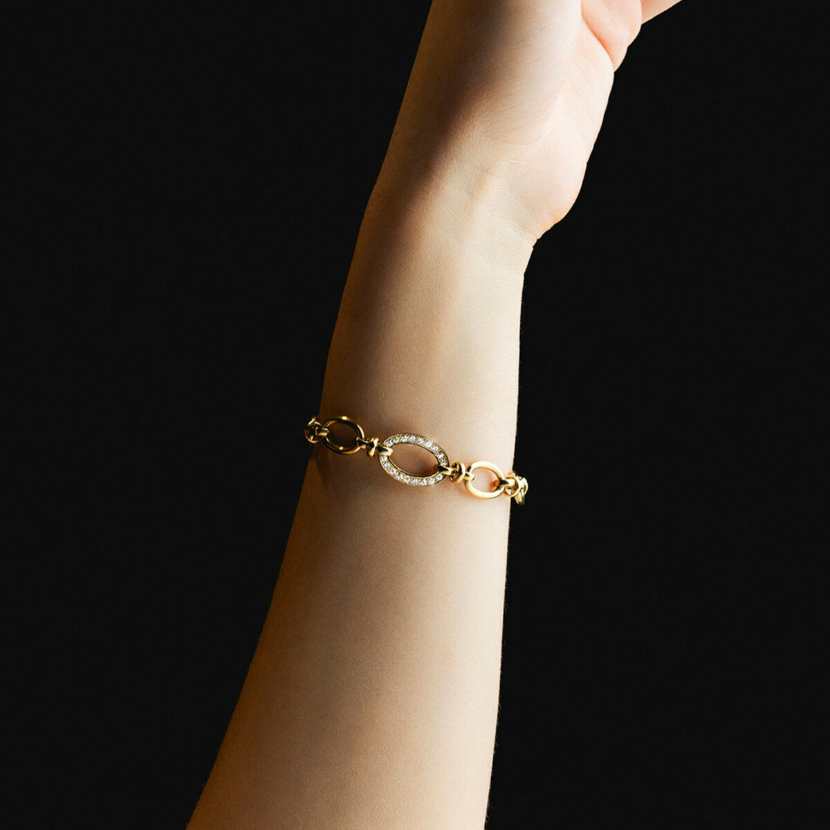 Detail van de gouden Lotus armband met verfijnde schakels, gedragen om een pols.