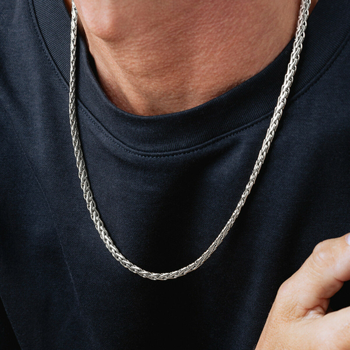 Detail van de Lotus ketting in zilver, elegant gedragen op een donkere trui.