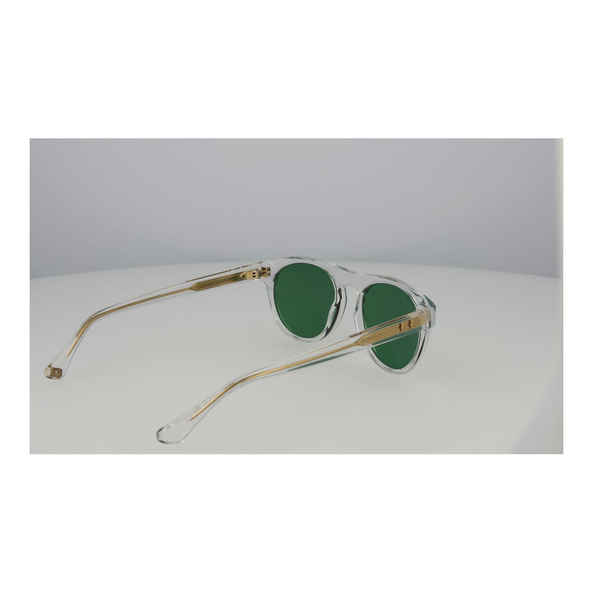 Zijaanzicht van de Web Eyewear zonnebril met groene lenzen en transparante montuur.