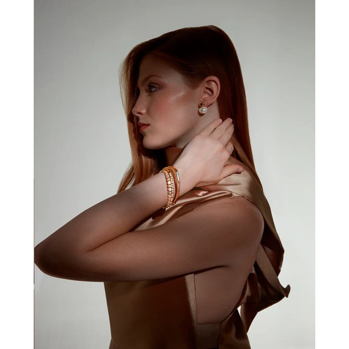 Gouden Viceroy armband elegant gedragen door vrouw met lange, kastanjebruine haren.