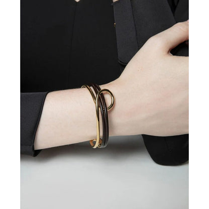Zijaanzicht van de zwarte en gouden Viceroy armband op een pols.