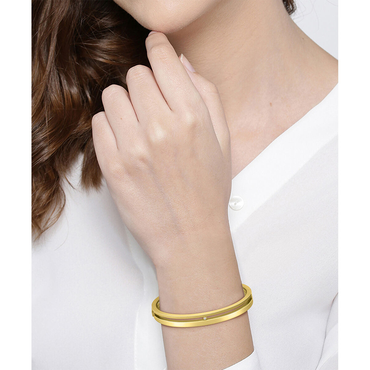 Detail van de gouden Hugo Boss damesarmband om een hand, elegant ontwerp.