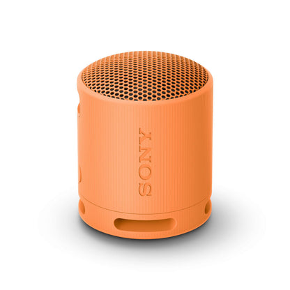 Oranje Sony SRSXB100D Bluetooth luidspreker, zijaanzicht met tekstlogo en gaasstructuur.