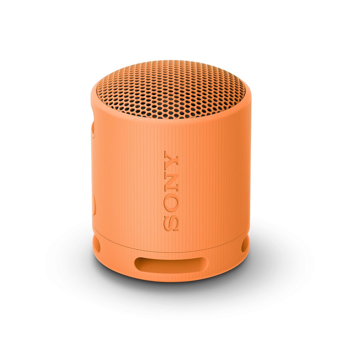 Detail van de oranje Sony SRSXB100D Bluetooth luidspreker met een ronde bovenkant en textuur.