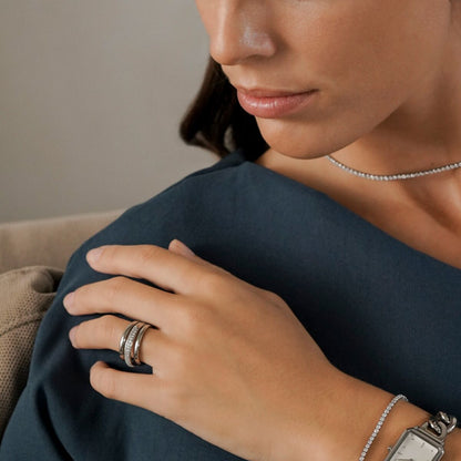 Zilverkleurige One Jewels ring op de hand van een vrouw, elegant gecombineerd met andere sieraden.