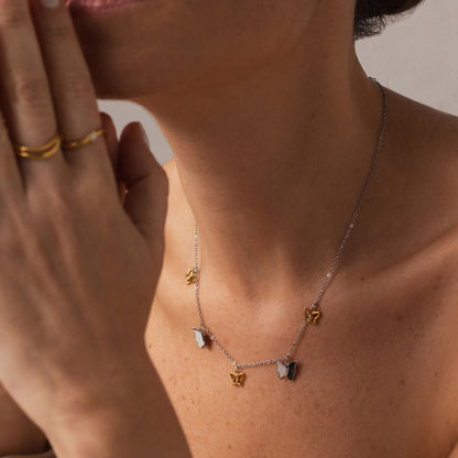 Detail van de zilverkleurige One Jewels ketting met gouden hartjes en een vrouwelijk model.