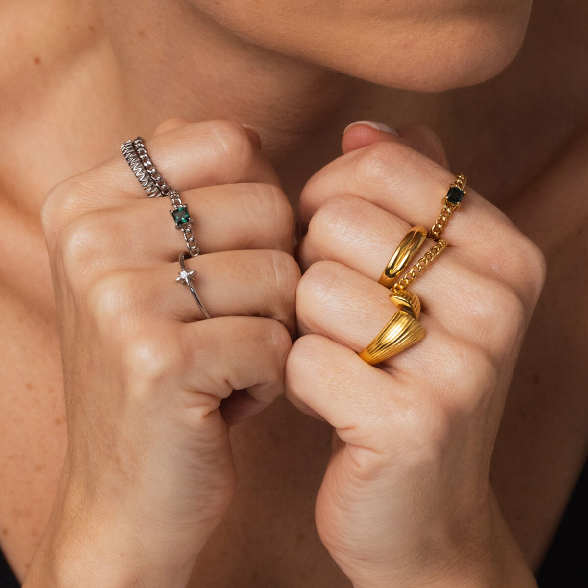 Detail van de gouden One Jewels ring, gedragen samen met andere elegante ringen.