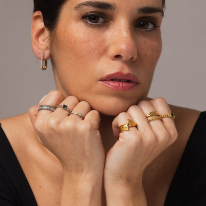 Detail van de One Jewels gouden ring, gedragen op de ringvinger met andere sieraden.