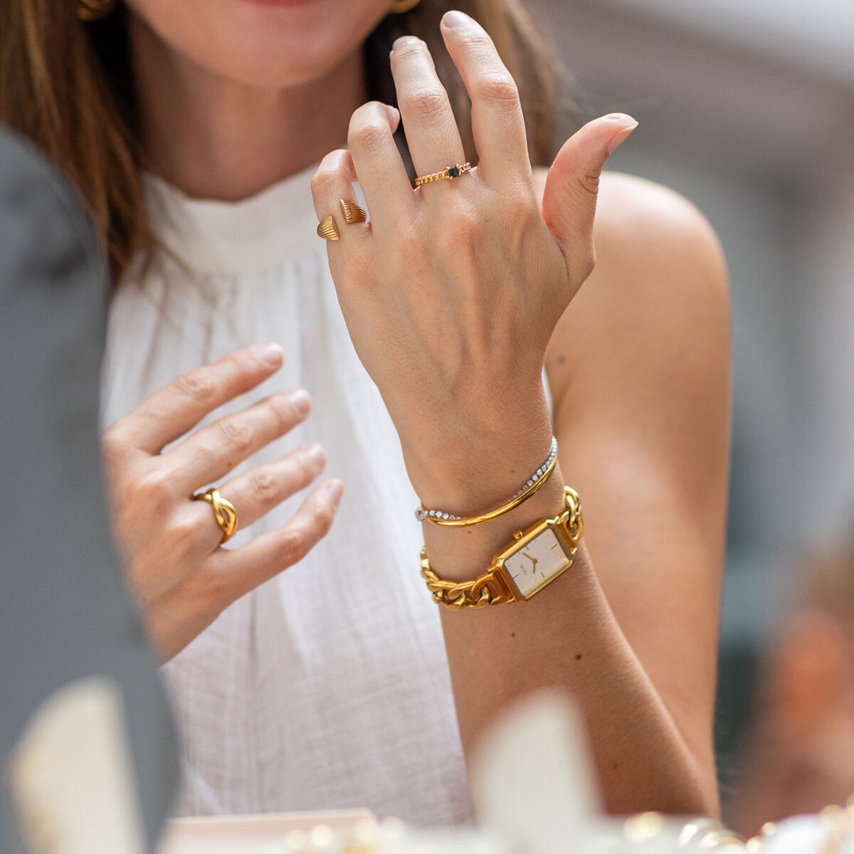 Detail van de One Jewels gouden armband, gedragen met bijpassende sieraden.