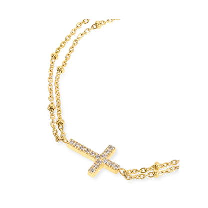 Detail van de gouden One Jewels armband met glinsterende kruisbedel.
