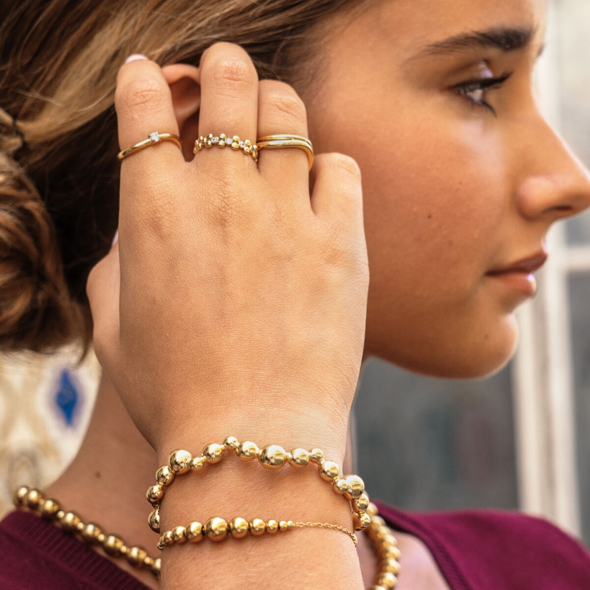 Detail van de One Jewels gouden armband gedragen door een vrouw, met elegante bolletjes.