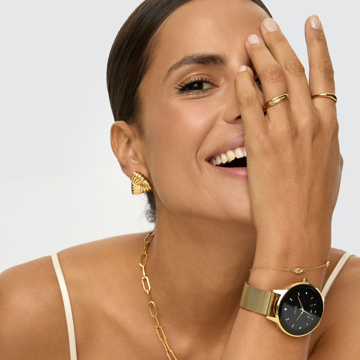 Detail van de One Jewels gouden oorbellen, elegant gedragen door een vrouw met accessoires.