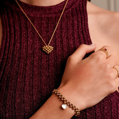 Detail van een hand met de One Jewels gouden ring en een bijpassende armband, casual gedragen.