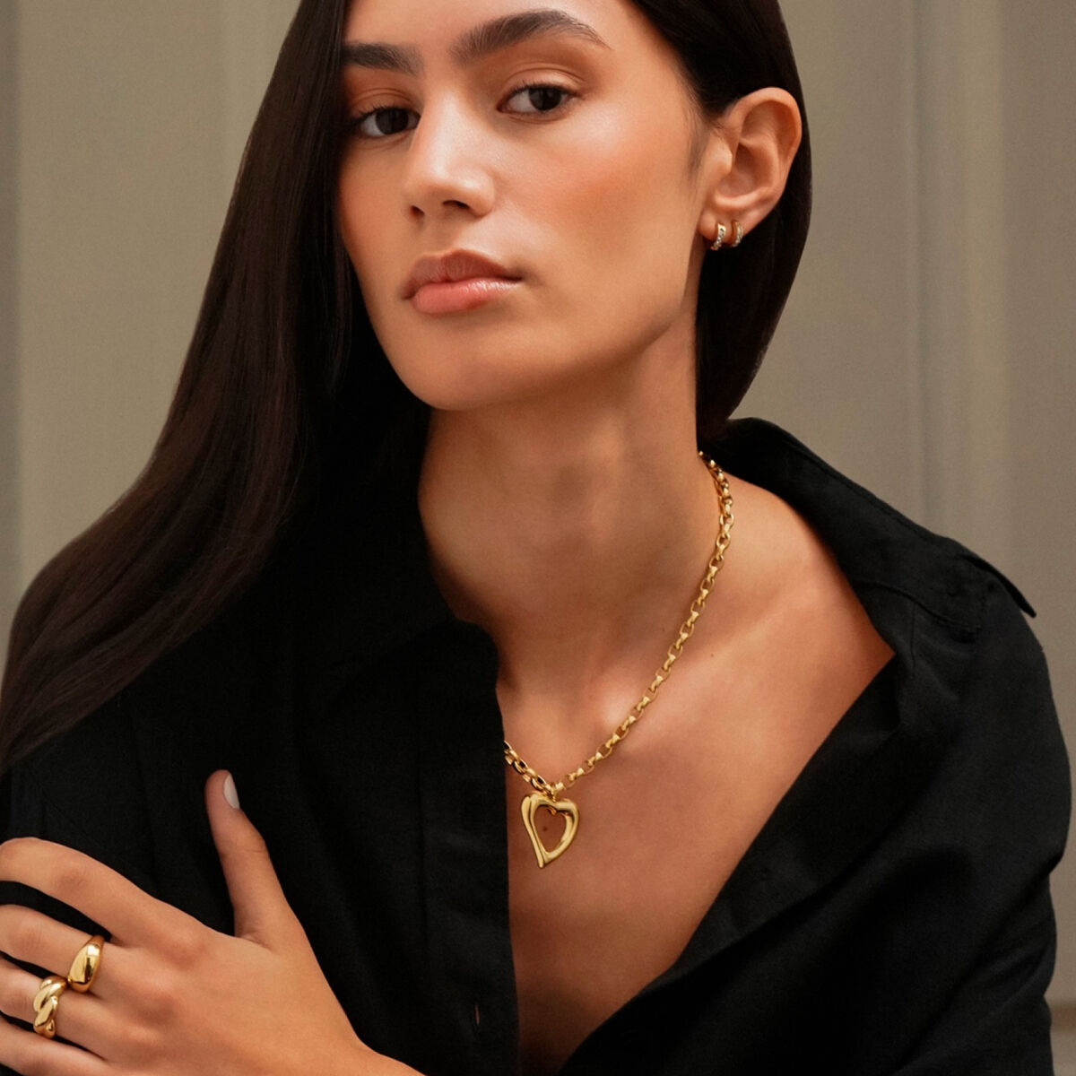 Damesketting van One Jewels met gouden hartje, gedragen door model in zwarte blouse.