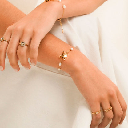Detail van de One Jewels ring in goud, gedragen met een elegante armband.