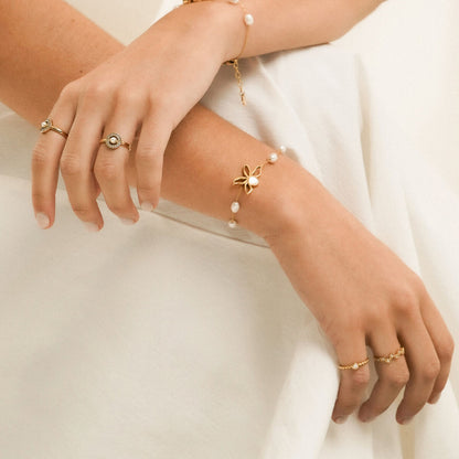 Detail van de One Jewels ring in goud, gedragen met elegante armbanden en een verfijnde uitstraling.