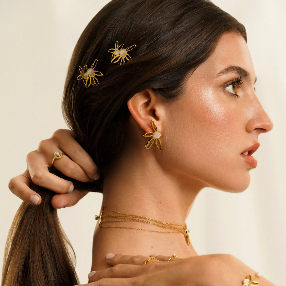 Detail van de gouden One Jewels oorbellen in elegant ontwerp, gedragen door een model.