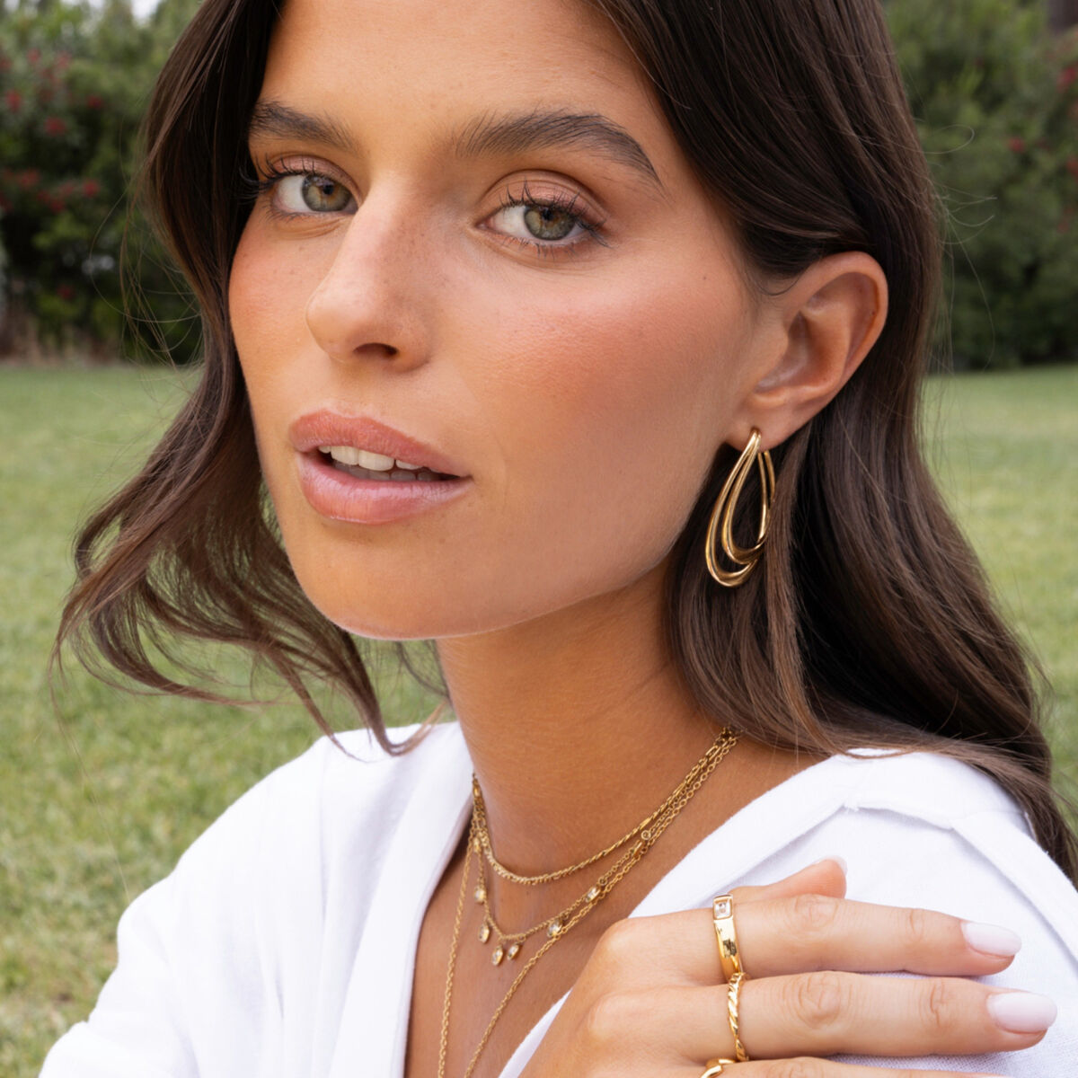 Detail van de elegante gouden One Jewels oorbellen in een model met een natuurlijke uitstraling.
