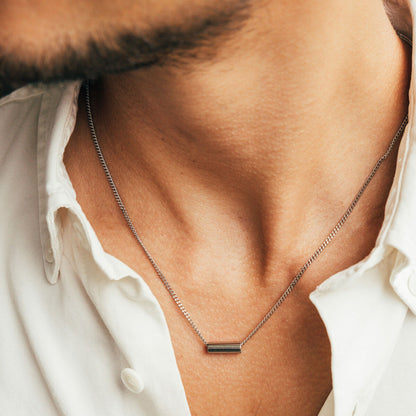 Zilverkleurige One Jewels ketting met een elegant, minimalistisch ontwerp, gedragen op de huid.