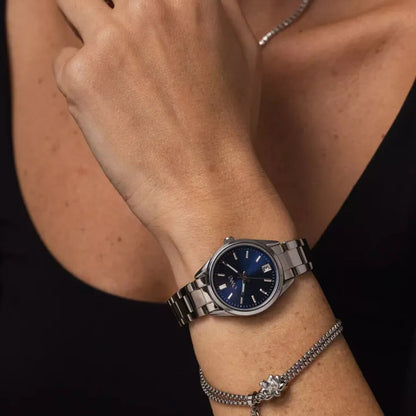 Zilverkleurige One Jewels armband gedragen om een pols met een blauwe horloge.