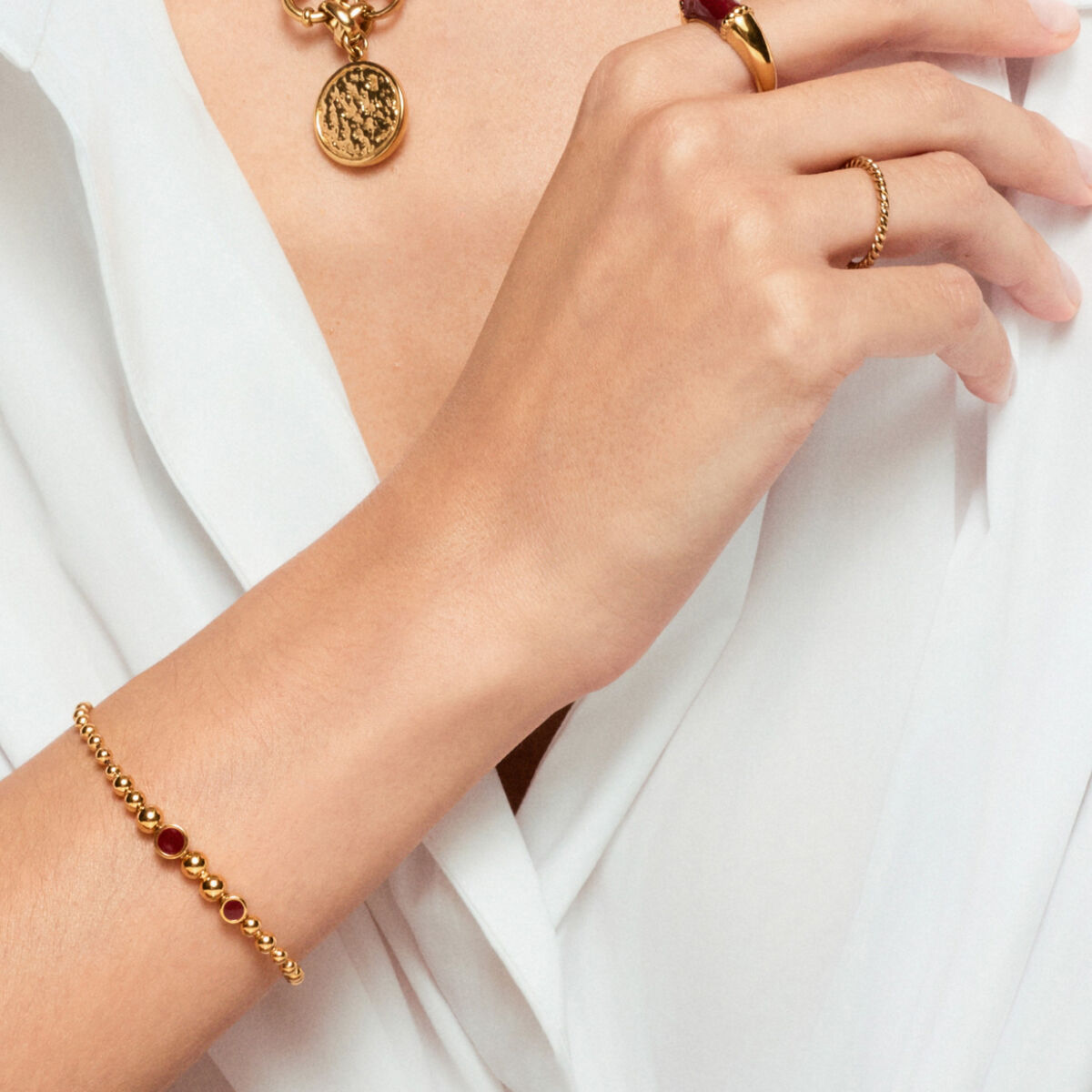 Detail van de One Jewels gouden armband met ronde kralen, gedragen op een hand.