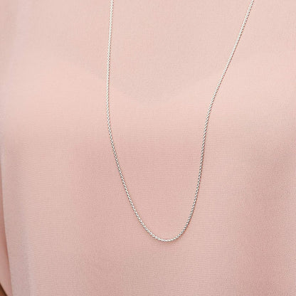 Zilverkleurige Pandora ketting, elegant detail zichtbaar op een roze blouse.