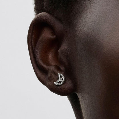 Zilverkleurige Pandora oorbel met elegante maansikkelvorm, dichtbij het oor.