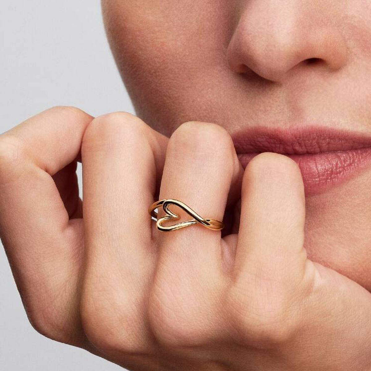 Detail van de gouden Pandora ring met een elegante, hartvormige design gedragen op de hand.