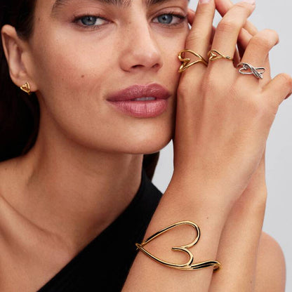 Detail van de gouden Pandora ring gedragen door een model met elegante sieraden.