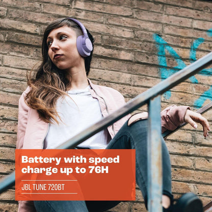 Vrouw met paarse JBL T720BTPUR oordopjes, zittend op een trap met een casual outfit.