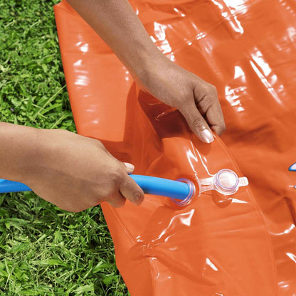 Detail van de oranje waterglijbaan met een hand die de luchtinlaat sluit.