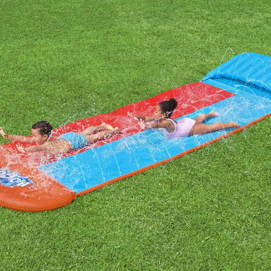Twee kinderen glijden samen van de Bestway H2OGO Tsunami Splash Ramp waterglijbaan.