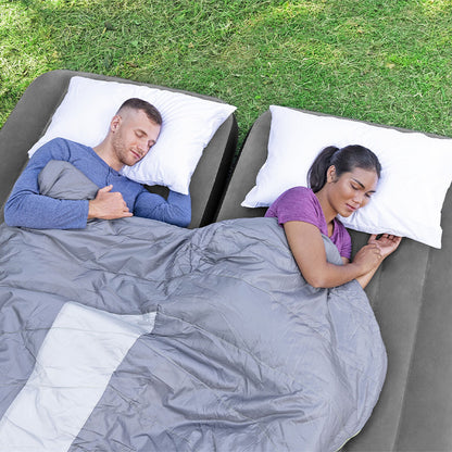 Twee personen liggen comfortabel op de Bestway opblaasbare matras, met dekens en kussens.