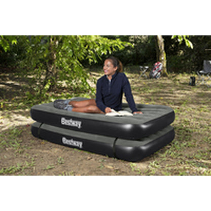 Detail van het Bestway 3 in 1 opblaasbare matras, met persoon zittend op de rand in de natuur.