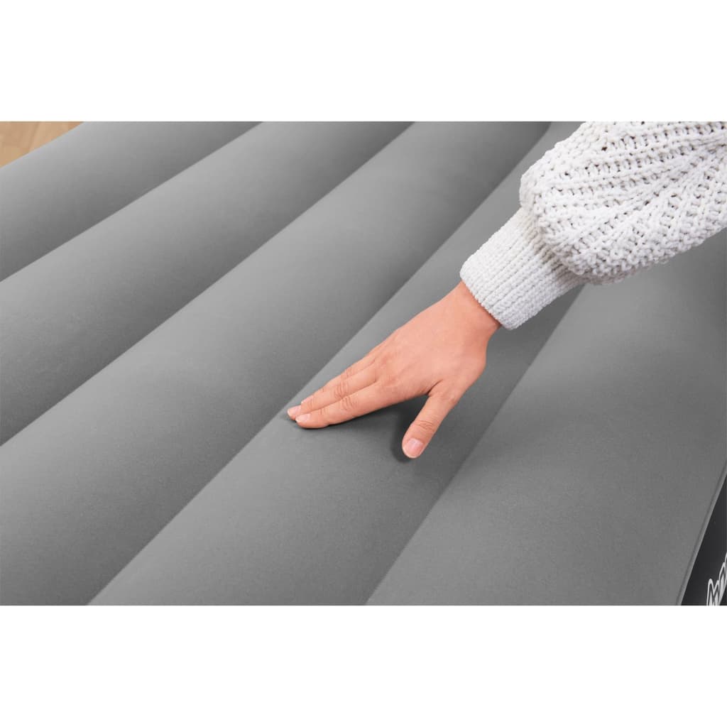 Detail van de gevlokte bovenkant van het Bestway luchtbed met hand erop.