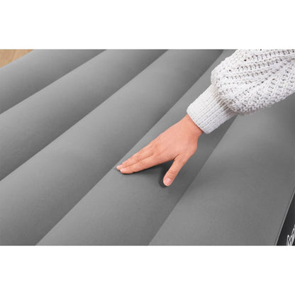 Detail van de gevlokte bovenkant van het Bestway luchtbed met hand erop.