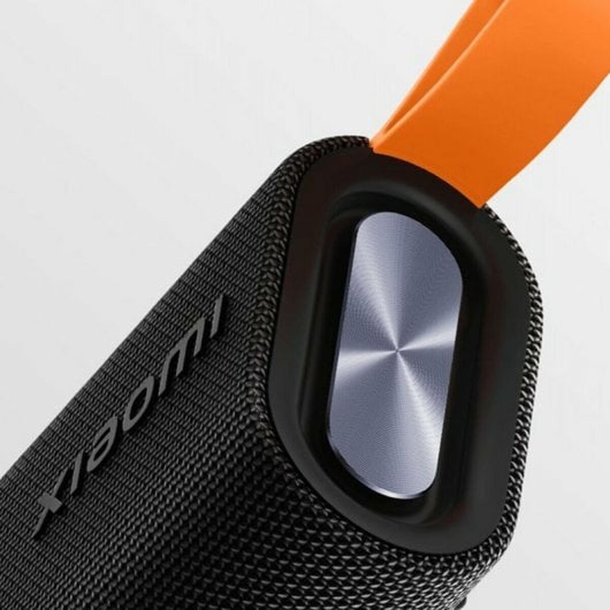 Detail van de Xiaomi Bluetooth luidspreker met een zwarte textuur en een oranje handvat.