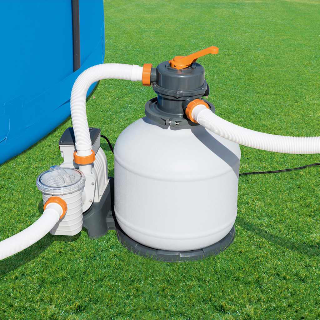 Detail van de Bestway zandfilterpomp met slangen en timer, zijaanzicht op gras.