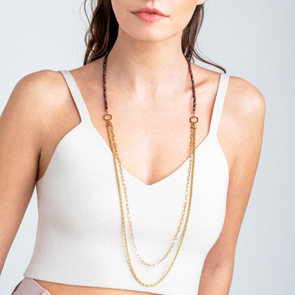 Detail van de Breil ketting met gouden en paarse schakels, gedragen door een model.