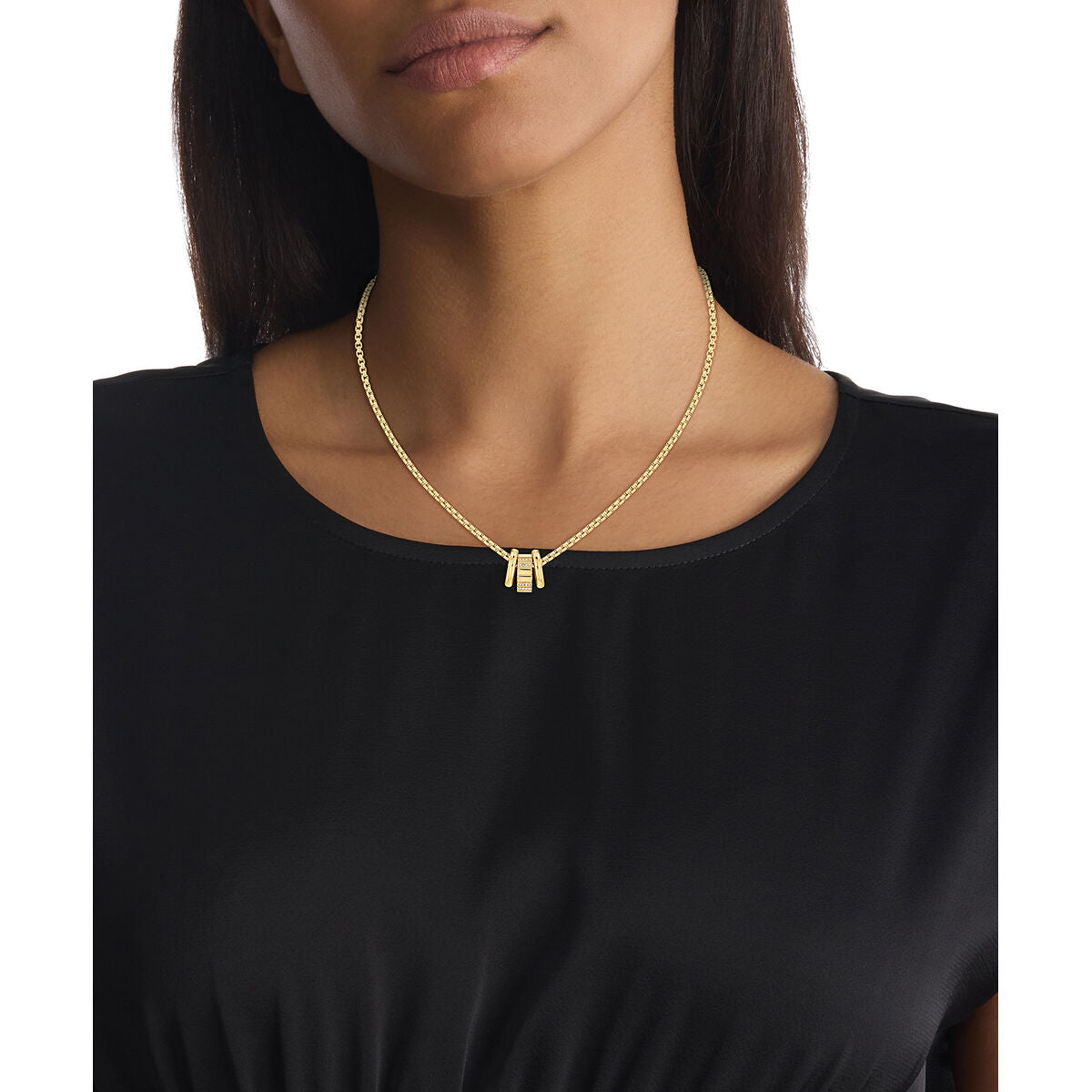 Detail van de Calvin Klein ketting in roestvrij staal, elegant gedragen boven een zwarte top.
