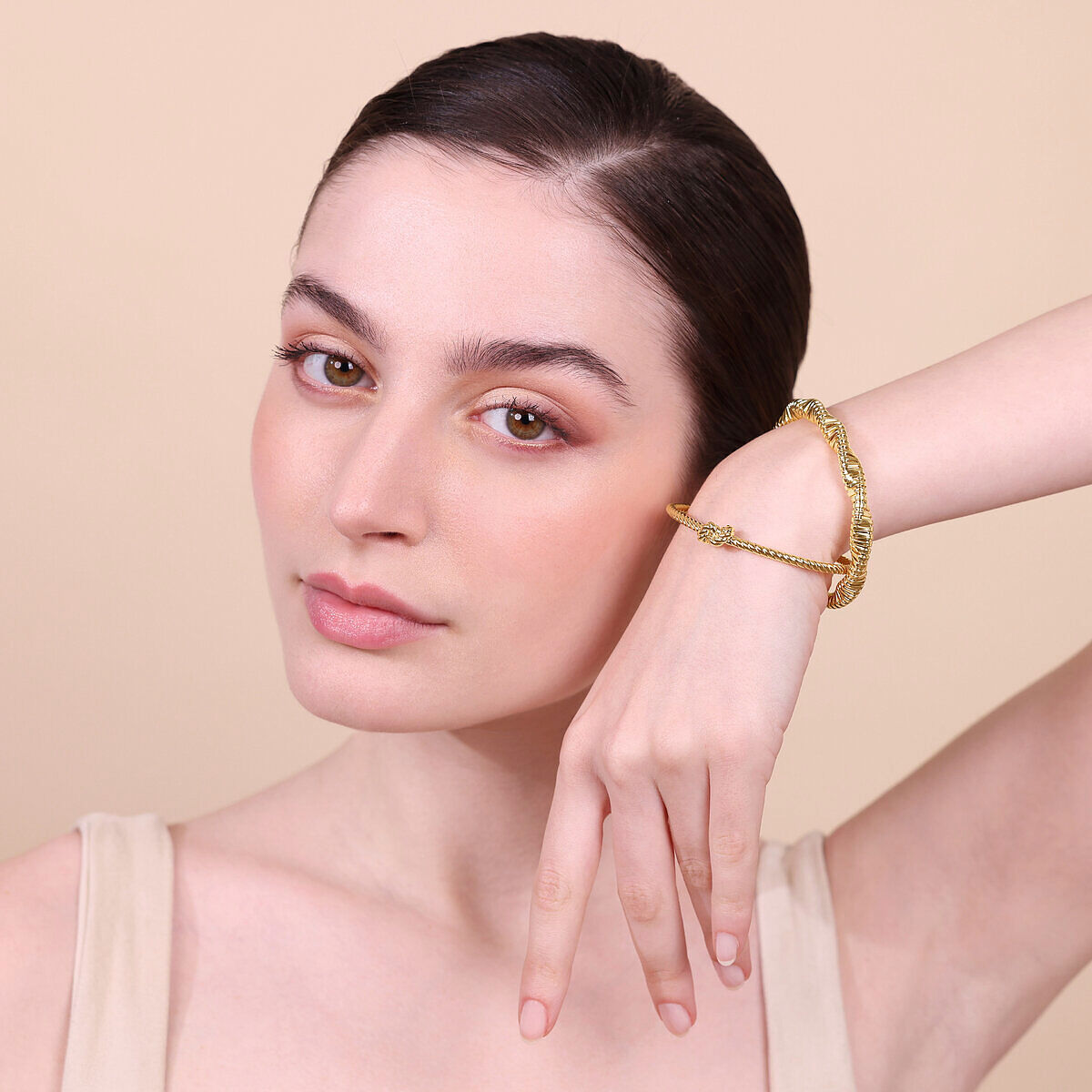 Elegante gouden Etrusca armband gedragen om de pols, met verfijnde details.