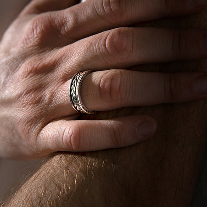 Zilverkleurige Albert M. ring met gedetailleerde band, gedragen op een hand.