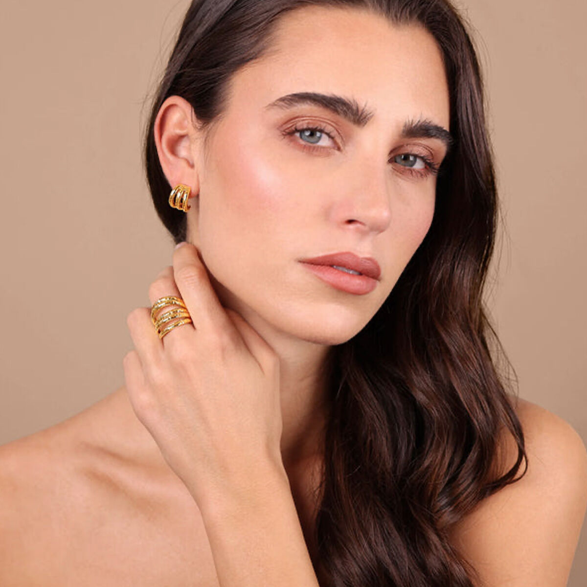 Detail van de Etrusca gouden oorbellen, gedragen door een model met sieraden.