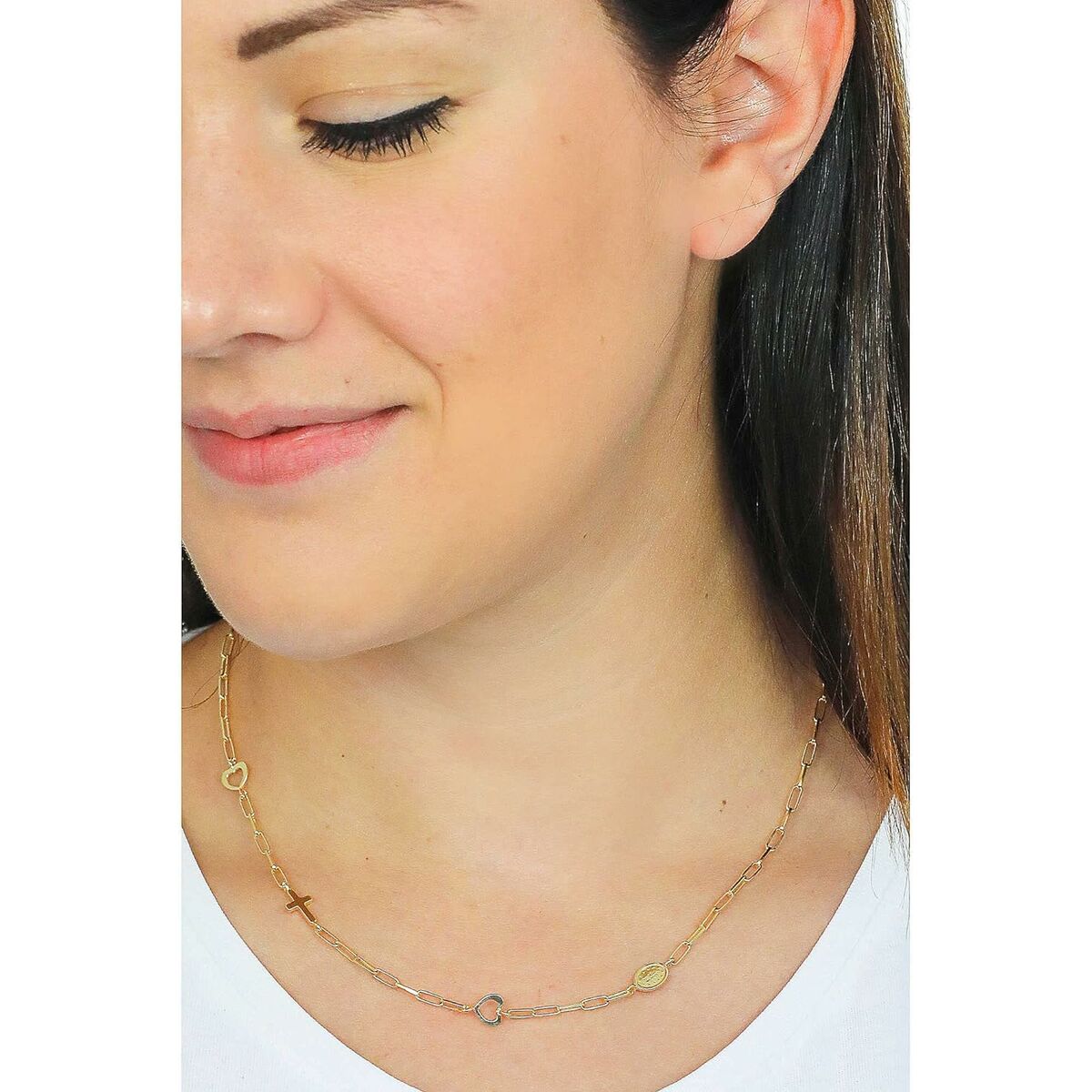 Detail van de goudkleurige Amen ketting met elegante hangers, gedragen door een vrouw.